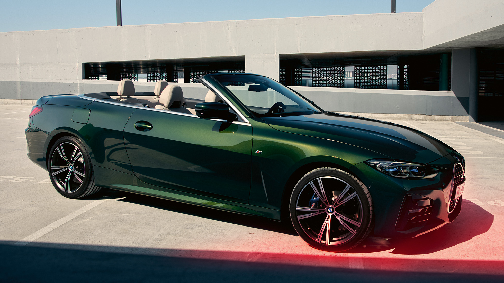 Vista de tres cuartos del frontal BMW Serie 4 Convertible G23 2020 con hombre BMW Serie 4 Convertible G23 2020 Sanremo Green metalizado, vista de tres cuartos del frontal, con un hombre al lado