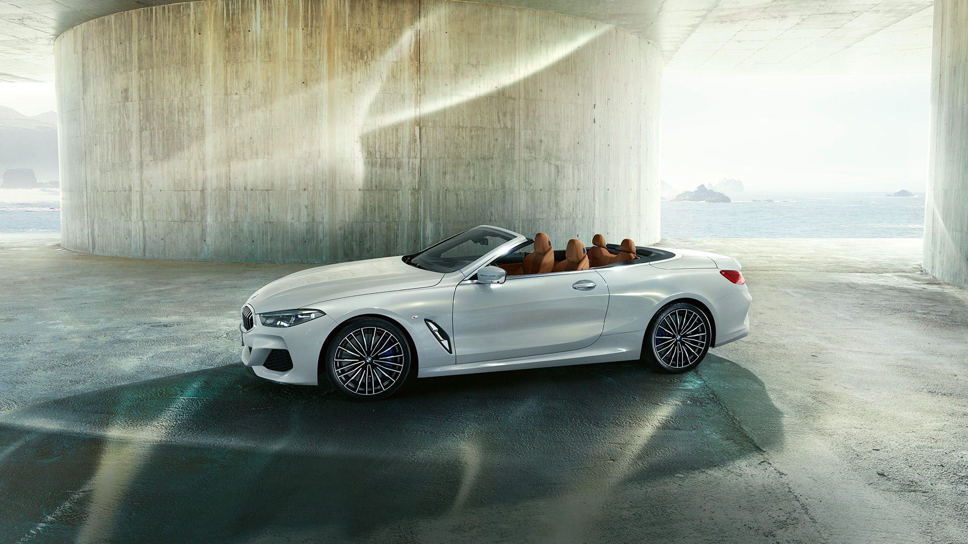 BMW M850i xDrive en Blanco Mineral metálico, vista lateral con la capota suave abierta. BMW M850i xDrive en Blanco Mineral metálico, vista lateral con la capota suave abierta.