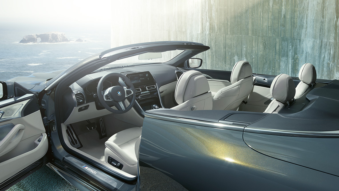 BMW M850i xDrive Gris Dravit metálico, interior, capota suave y puerta abierta. BMW M850i xDrive Gris Dravit metálico, interior, capota suave y puerta abierta.