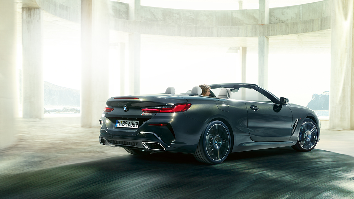 BMW M850i xDrive con capota abierta, en movimiento, vista lateral. BMW M850i xDrive con capota abierta, en movimiento, vista lateral.