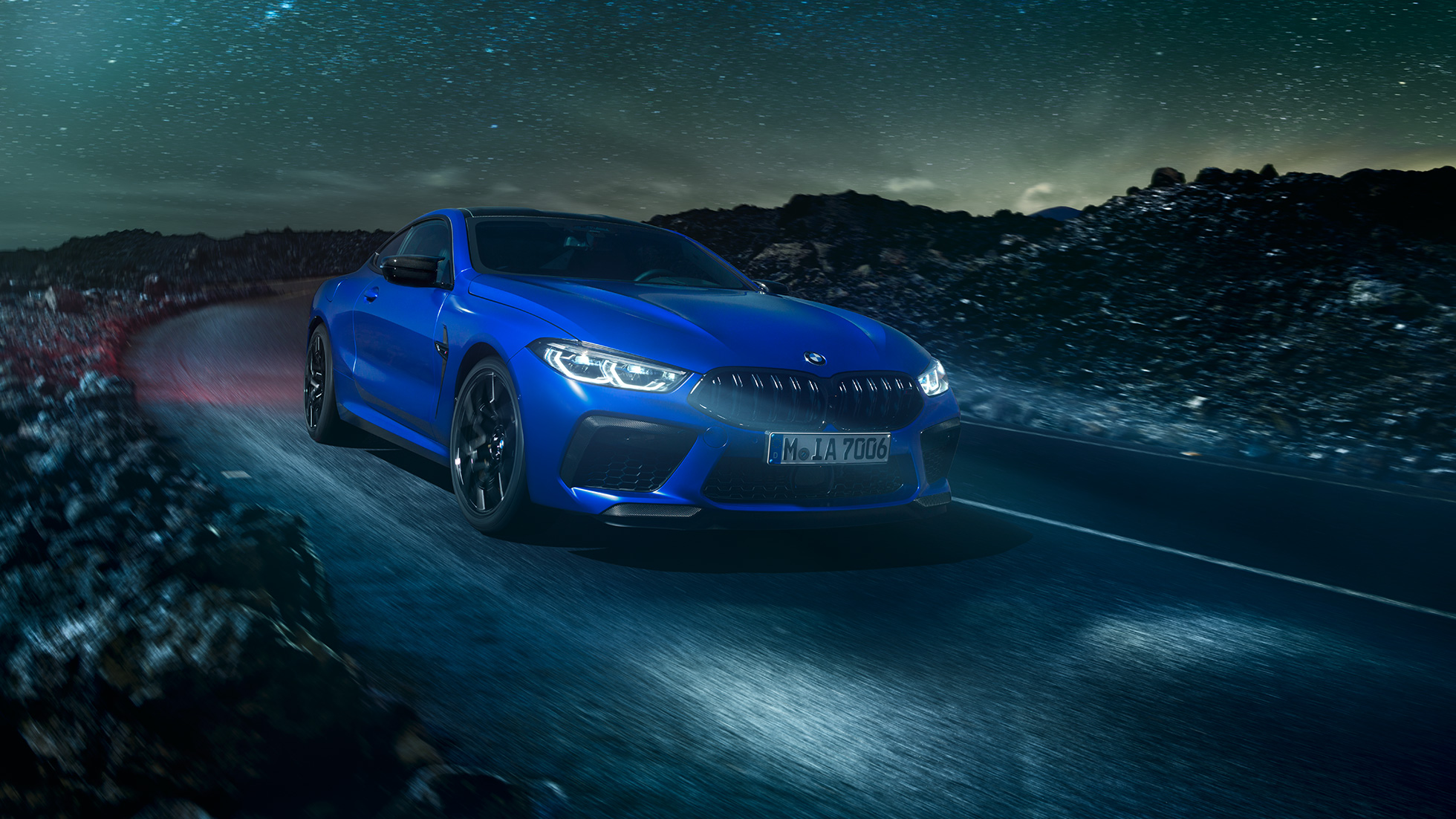 BMW M8 Competition Coupé, vista lateral. BMW M8 Competition Coupé en Marina Bay Blue metálico, vista lateral en alto frente al desierto con luna llena.