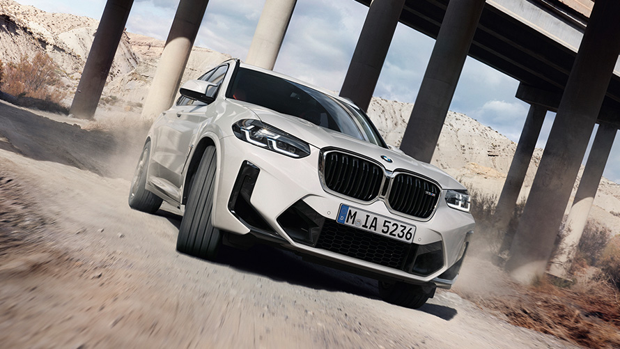 BMW X3 M F97 LCI Renovación 2021 Vista de tres cuartos del frontal, en marcha trazando una curva BMW X3 M F97 LCI Renovación 2021 Alpinweiss, vista de tres cuartos del frontal, en marcha trazando una curva