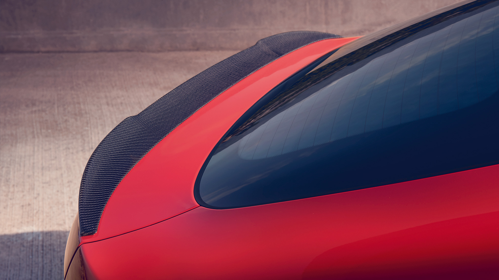 BMW X4 M Competition, M rear spoiler in carbon. BMW X4 M Competition in Toronto Red metallic, exterior, M Carbon exterior package, detailed rear view with M rear spoiler in carbon.