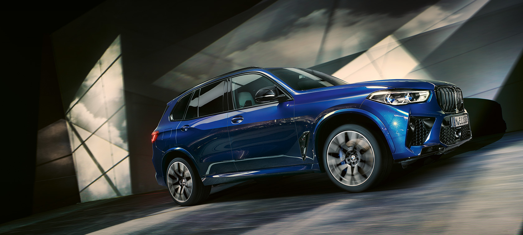 Gama BMW X5 M F95 2020 SUV BMW X5 M Competition Marina Bay Blue metalizado, vista de tres cuartos del lateral, perspectiva desde ángulo inferior, en marcha